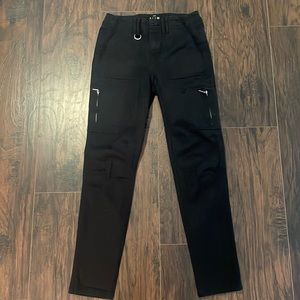 Black crop pants with silver buttons and details.